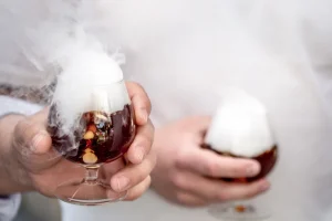 Cocktail fumant avec glace carbonique, démonstrations de production et manipulation sécurisée violonisée, ambiance laboratoire Delta Diffusion.